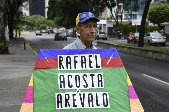 An opposition activist carries a kite with the name of recently deceased navy captain Rafael Acosta in Caracas: the US said it will impose snactions on the intelligence agency accused or torturing him to death