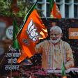 A billboard with an image of Indian Prime Minister Narendra Modi is surrounded by Bharatiya Janata Party (BJP) flags