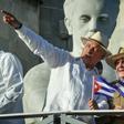 Cuban President Miguel Diaz-Canel (with his arm raised) stands next to Raul Castro, first secretary of the island's Communist Party, on May 1, 2019 in Havana; a new law will bring governmental change without touching the central role of the party