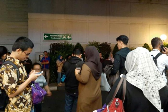 Office workers mill around after evacuating a building in Serpong, Banten province, following a strong earthquake off the southern coast of Indonesia's heavily populated Java island