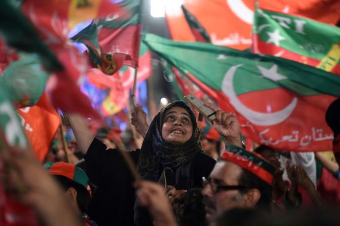 Pakistan Tehreek-e-Insaf supporters wave party flags during campaigning that brought Imran Khan to power in July 2018