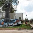 A portrait of Syrian President Bashar al-Assad stands near a sculpture in the Syrian town of Quneitra, in the Golan Heights