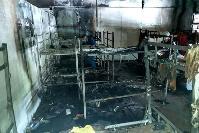 Investigators work after a fire in a shelter for migrants in the town of Velika Kladusa