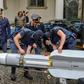 This handout picture released by the Italian police (Polizia di Stato) of Turin, on July 15, 2019, shows italian policemen carry an air-to-air missile, as part of a big cache of guns and ammunition that was seized by the Turin special police force, cal...