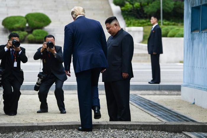 North Korea's leader Kim Jong Un looks on as US President Donald Trump steps into the northern side of the Military Demarcation Line that divides North and South Korea, in the Demilitarized zone (DMZ) on June 30, 2019