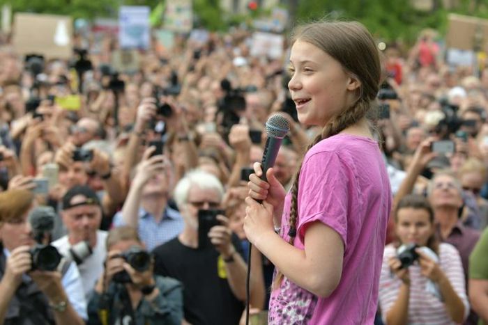 Swedish teenage activist Greta Thunberg addresses a rally in Berlin, while Chancellor Angela Merkel praised her nearby in the German capital