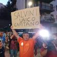 A man holds a placard reading "Salvini is the only captain"
