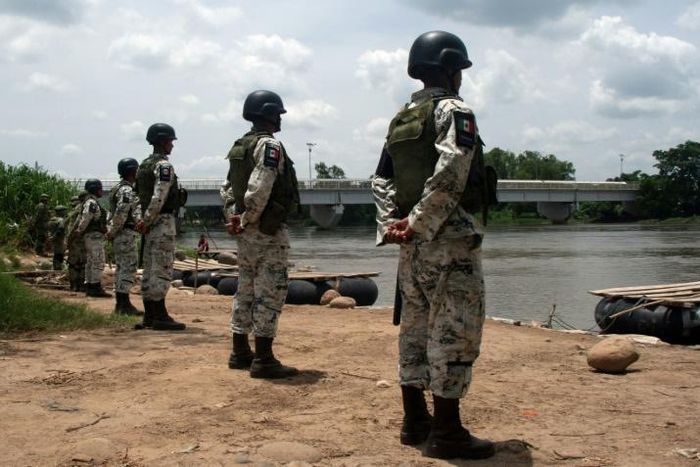 Mexican National Guard members stand along the banks of the Suchiate River in Ciudad Hidalgo, Mexico, to prevent illegal crossings across the border river to and from Tecun Uman in Guatemala