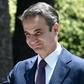 Greece's Prime Minister Kyriakos Mitsotakis waves as he leaves the presidential palace in Athens after being sworn in