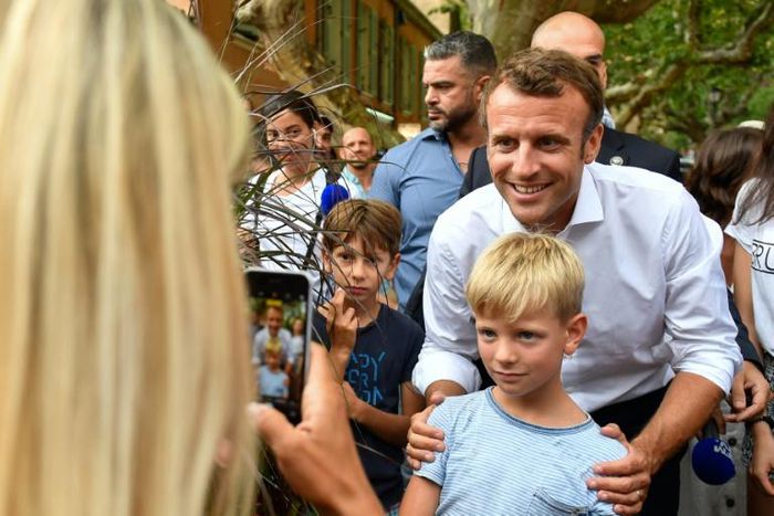 French President Emmanuel Macron (C) on Saturday posed for pictures in Bormes-les-Mimosas, near the fort of Bregancon where he will host his Russian counterpart Vladimir Putin in August