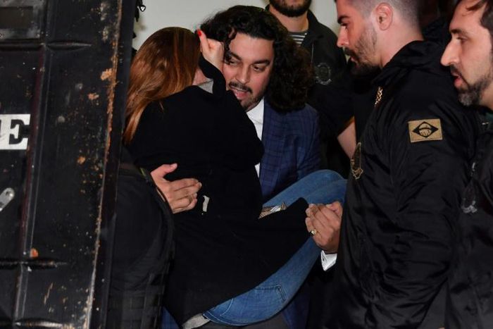 The woman who has accused Brazilian football star Neymar of rape, Najila Trindade Mendes de Souza, is carried out of a Sao Paulo police station by her lawyer Danilo Garcia de Andrade -- he has now abandoned her as a client