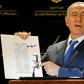 Israeli Prime Minister Benjamin Netanyahu displays a map of Israel, signed by US President Donald Trump, showing the Golan Heights as being inside Israel's borders