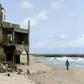 The shore-hugging Alpha Beach road has disappeared under the waves and apartment blocks built with prized ocean views just 10 years ago are now occupied only by squatters
