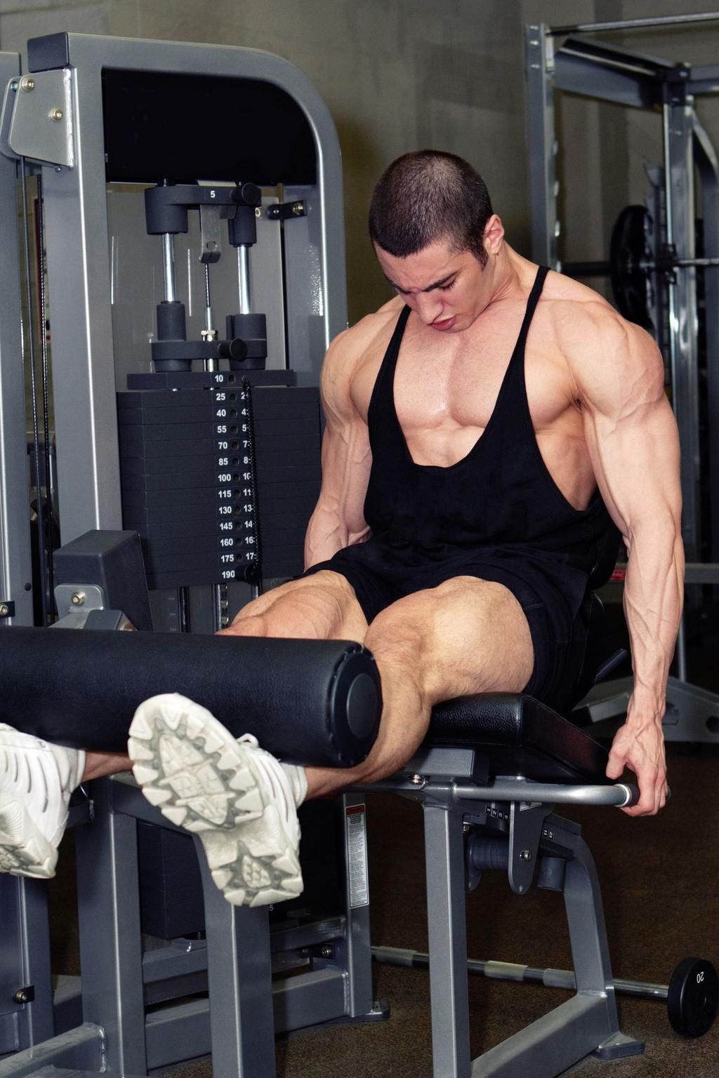 Muscular man doing legs workout in fitness club
