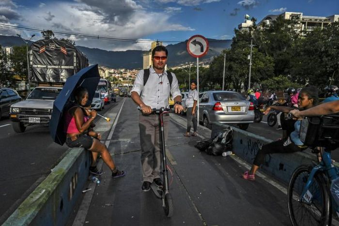A man rides an electric scooter in the Colombian city of Medellin -- one of many cities in Latin America where the scooters are popular, and wreaking havoc on traffic