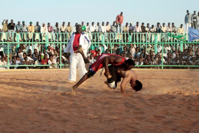 In this file photo from 2013, Japanese diplomat Yasuhiro Murotatsu, aka "Muro" (R) competes against Saleh Omar Bol Tia Kafi aka "al-Mudiriya" in a Nuba wrestling match in Khartoum