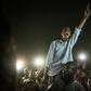 A man recites a revolutionary poem, as people gather in a southern district of Khartoum