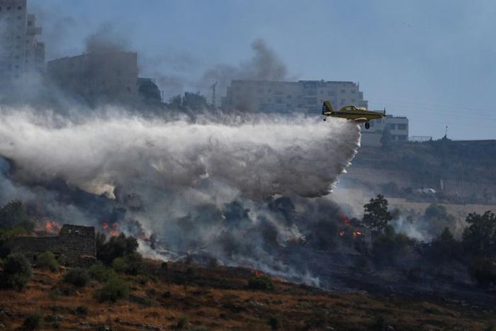 A plane extinguishes a fire in the Jerusalem area on July 18, 2019