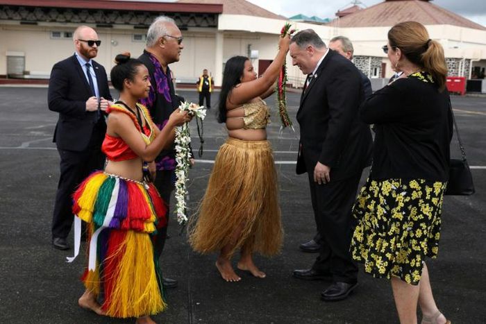 US Secretary of State Mike Pompeo and his wife Susan are greeted by women with traditional mwar mwar floral wreaths as they arrive at Pohnpei International Airport in Kolonia, Micronesia