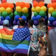 Participants in the LA Pride Parade in West Hollywood cover themselves with the rainbow flag of the gay rights movement