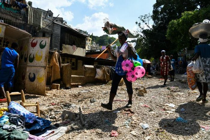 A woman sells toys at the site of a landslide in Port-au-Prince on July 3