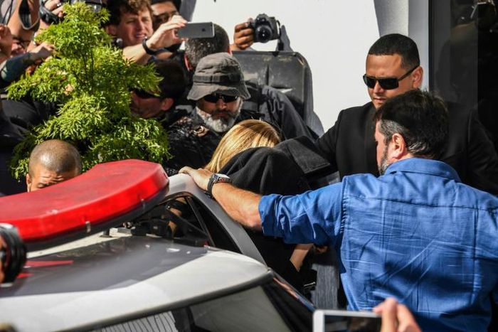 Najila Trindade (C-covered with a black jacket) arrives at a police station in Sao Paulo, Brazil on June 7, 2019 after accusing football superstar Neymar of rape