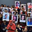 Relatives and friends of victims of the 2009 coup that ousted former president Manuel Zelaya hold portraits of their loved ones during a forum in Tegucigalpa on June 27, 2019