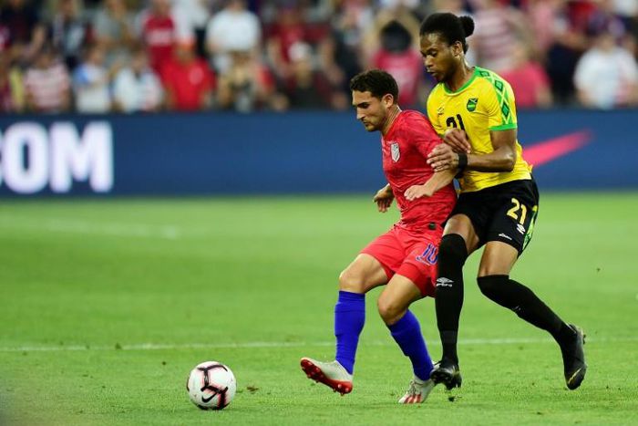 The USA's Cristian Roldan and Kevon Lambert of Jamaica battle for the ball in their friendly international