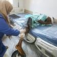 A nurse cleans the wound of a wounded migrant at a medical emergency ward in a Tripoli hospital on Wednesday