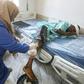 A nurse cleans the wound of a wounded migrant at a medical emergency ward in a Tripoli hospital on Wednesday