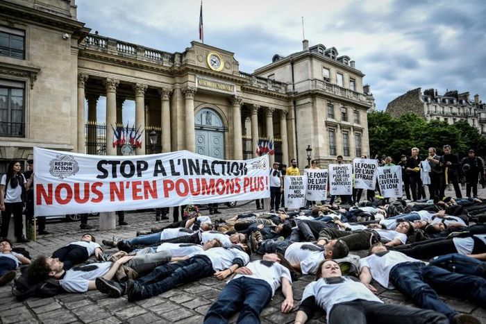 Activists stage a "die-in" on June 4, 2019 to denounce the air quality outside the French National Assembly in Paris