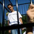 Three teens wearing t-shirts with "#ClassroomsNotCages" scrawled across the front stood inside a small cage erected outside the gates of the United Nations's European headquarters