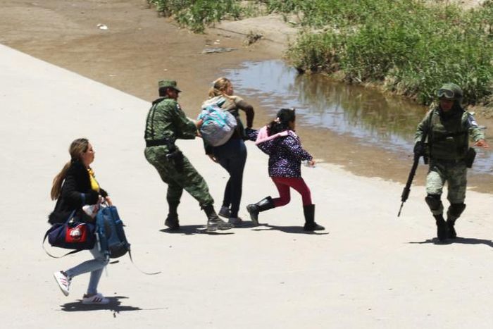 Members of Mexico's National Guard prevent a mother and daughter from crossing the border into the US from Juarez, Mexico
