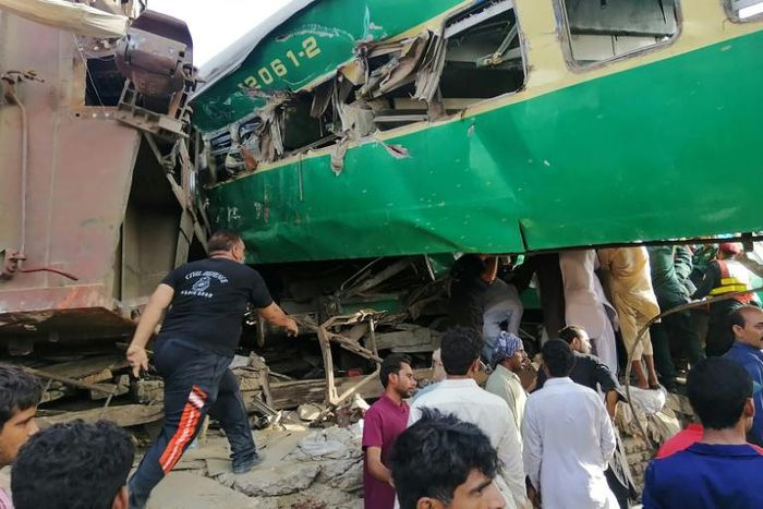 Rescuers and onlookers gather around the twisted wreckage of train carriages after the accident