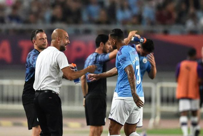 Pep Guardiola gives intructions to his Manchester City players on the sideline in Nanjing