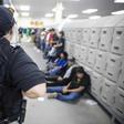 A Homeland Security officer guards some of the 680 suspected undocumented migrants detained in Mississippi after Immigration and Customs Enforcement officers raided several slaughterhouses