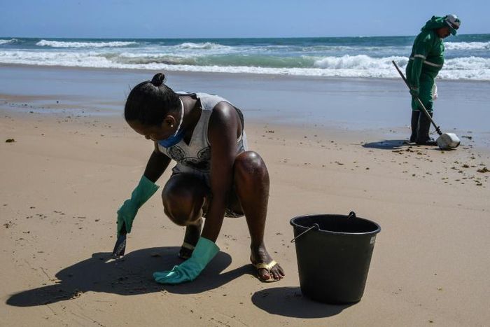 Council workers scrape spilled crude off the beach in Itapuama in northeastern Brazil as the country rushes to prepare for the peak tourism season