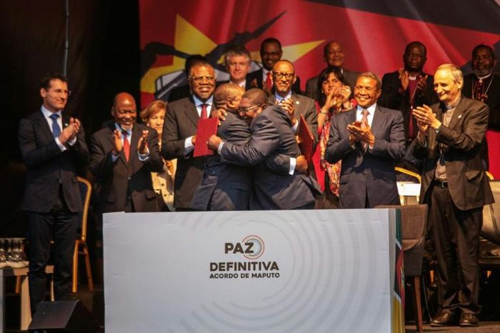 Mozambique's President Filipe Nyusi and Renamo leader Ossufo Momade hug after signing the landmark peace agreement on August 6