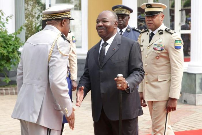 Bongo, centre, shakes hands at a ceremony to honour Gabon's first president