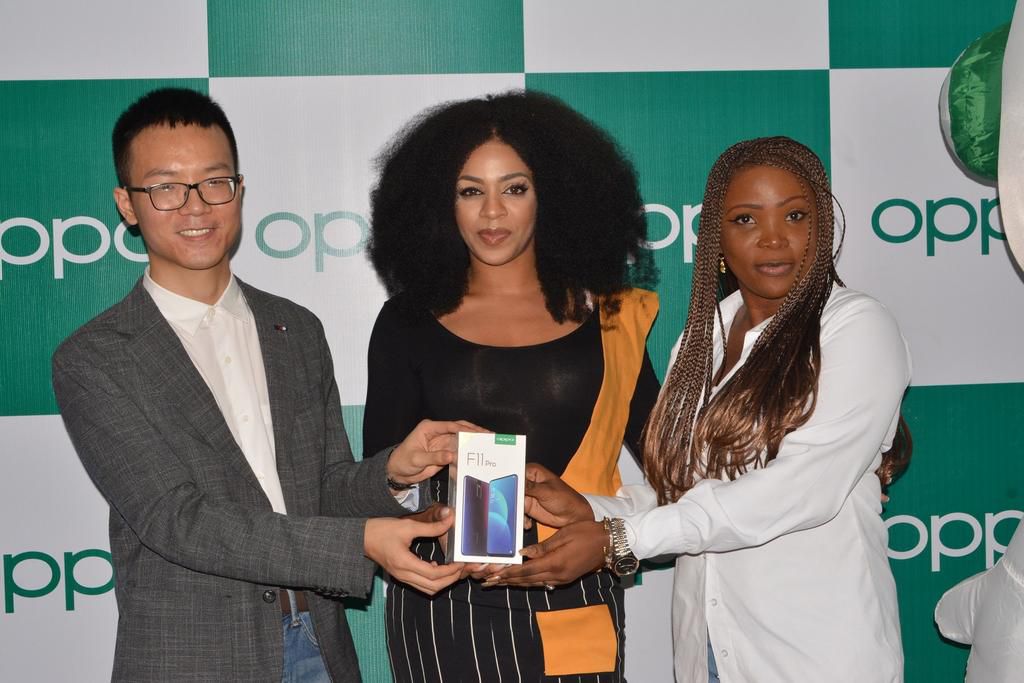 LEFT, Kris Cao, Marketing Director OPPO Nigeria and RIGHT, Nengi Akinola, Marketing Manager, OPPO Nigeria gifiting the OPPO F11 Pro to Venita at the OPPO Head Office, Lagos