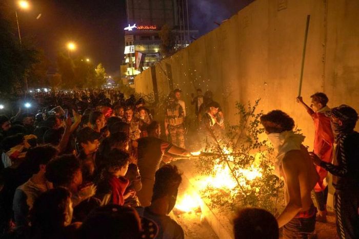 Iraqi demonstrators set tires ablaze behind the walls protecting the Iranian consulate in the Shiite holy city of Karbala, south of Iraq's capital Baghdad, on November 3