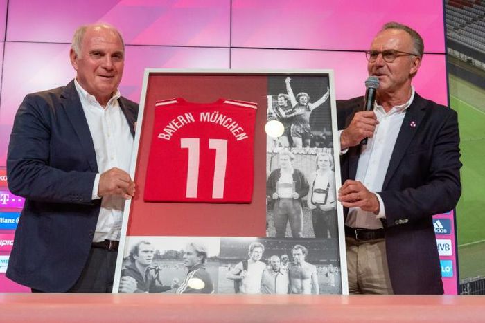 Uli Hoeness (L) receives a framed Bayern Munich shirt from club chairman Karl-Heinz Rummenigge, after revealing he is standing down as club president