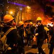 Thick, black smoke swirled from a large fire started by masked Hong Kong protesters at a barricade on a major thoroughfare