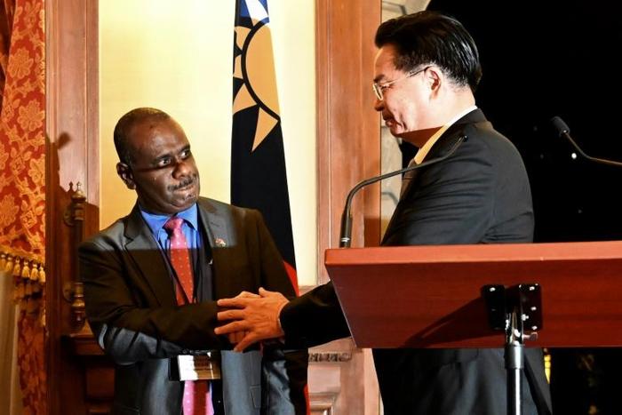 Taiwan Foreign Minister Joseph Wu shakes hands with Solomon Islands' Foreign Minister Jeremiah Manele during a press conference in Taipei. The Solomon Islands is mulling scrapping diplomatic links with Taipei in favour of Beijing