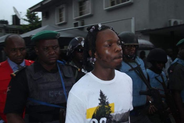 Naira Marley being led to court by men of the EFCC amidst a watertight security. [Twitter/@officialEFCC]