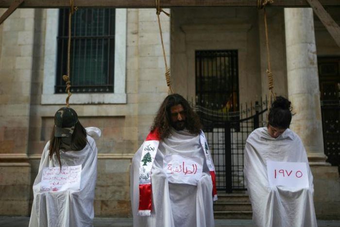 Lebanese protesters stage a mock hanging in a symbolic performance against sectarianism (C), Lebanon's 1975-90 civil war (R) and corruption during ongoing anti-government demonstrations in Beirut on November 3, 2019