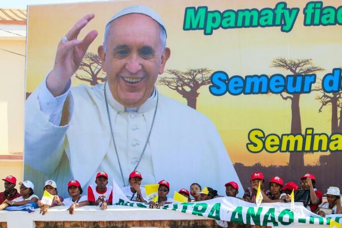 Catholic worshippers wave Vatican flags as they wait for Pope Francis near Ivato International Airport in Madagascar
