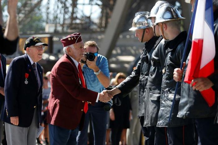 A veteran meets firefighters at the Eiffel Tower