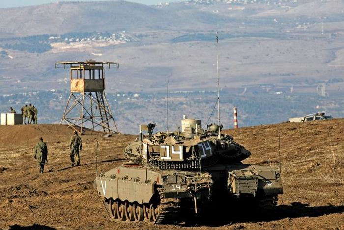 Israeli troops equipped with armoured vehicles survey neighbouring Syria from the Golan Heights, a strategic plateau Israel seized from Syria in the Six-Day War of 1967