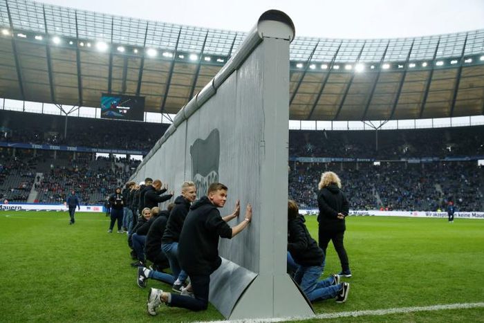 Volunteers prepare to knock down a mock-up of the former Berlin Wall bearing the inscription "Against Walls together with Berlin", before the Bundesliga match between Hertha Berlin and RB Leipzig on Saturday.